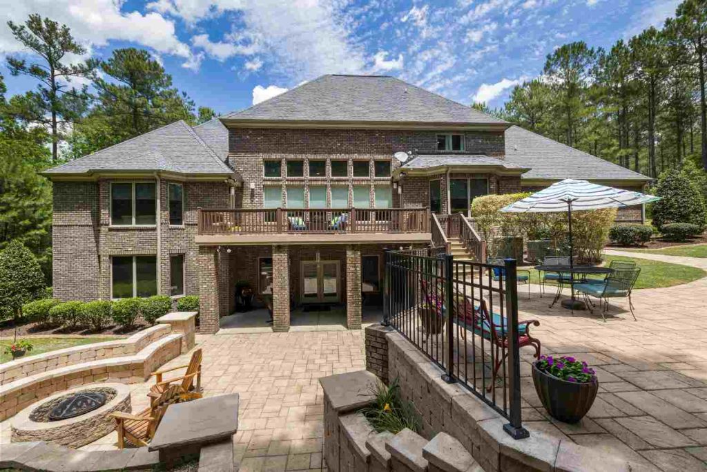 Brick residence with a deck and paver patio around a fire pit