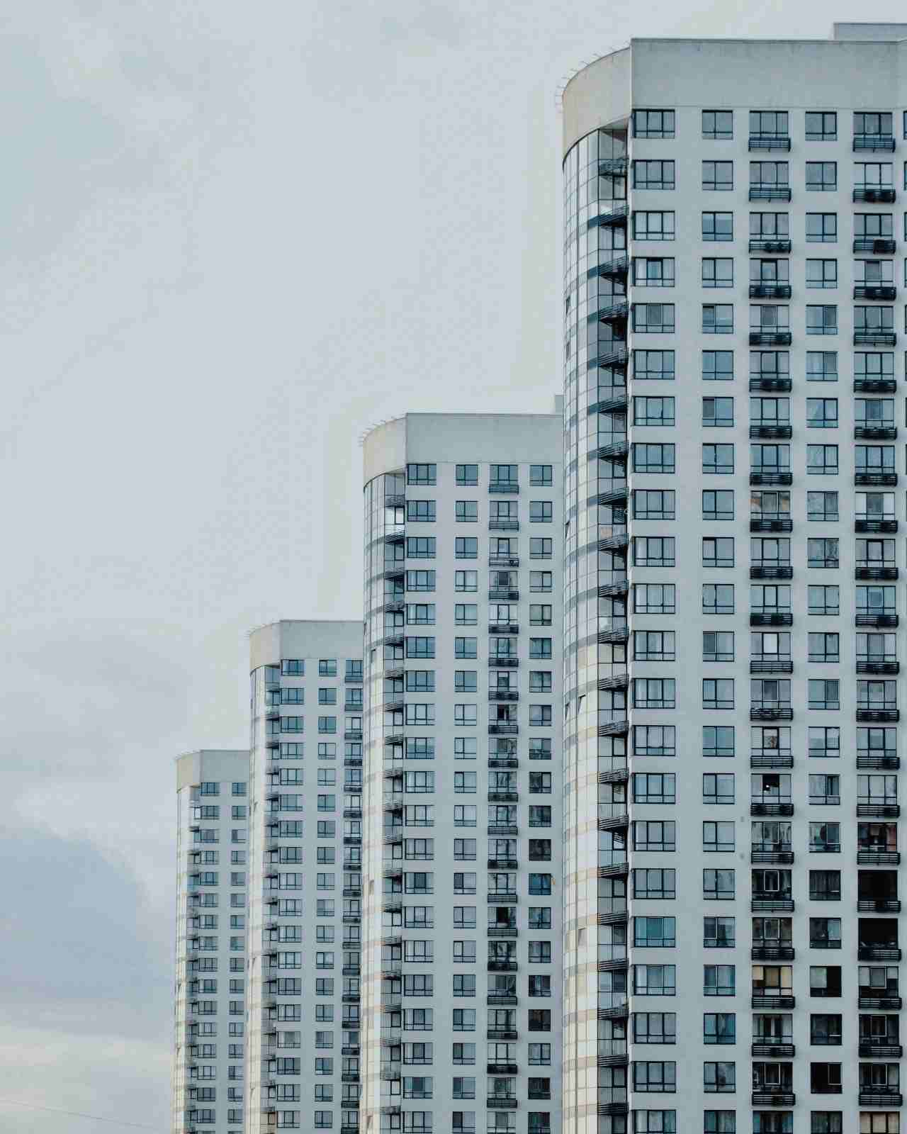 Curved white residential towers seen from below